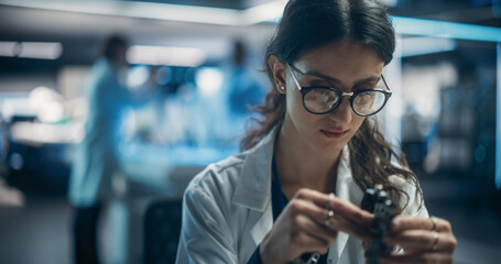 Focused Professional Female Engineer Working on Electronic Circuit Boards. Industrial Robotics...