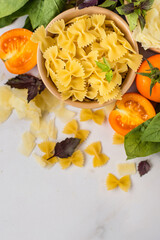 Rasta bantki pasta in a bowl with vegetables and herbs on a light background, top view..
