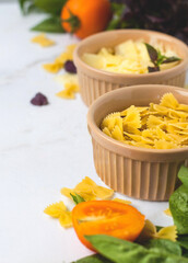 Rasta bantki pasta in a bowl with vegetables and herbs on a light background.