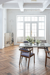 a view of a set dining table in a chic expensive bright interior of a huge living room in a historic mansion with arched arches, columns and white walls decorated with ornaments and stucco.