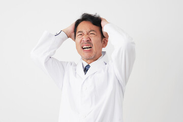 頭を抱えるミドルエイジの医師　白背景