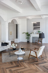 a chic expensive bright interior of a huge living room in a historic mansion with arched arches, columns and white walls decorated with ornaments and stucco.