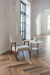 a chic expensive bright interior of a huge living room in a historic mansion with arched arches, columns and white walls decorated with ornaments and stucco.
