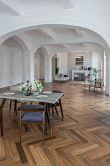a chic expensive bright interior of a huge living room in a historic mansion with arched arches, columns and white walls decorated with ornaments and stucco.