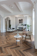 a chic expensive bright interior of a huge living room in a historic mansion with arched arches, columns and white walls decorated with ornaments and stucco.