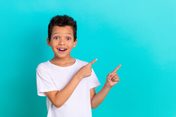 Photo of impressed boy wear stylish white clothes two arm direct empty space buy pajama special offer isolated on cyan color background