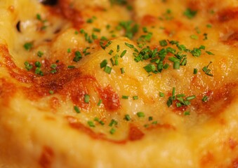 mushroom soup with puff pastry crust and chopped green onion close up view
