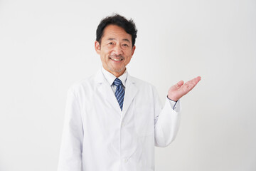手のひらで右側を指すミドルエイジの医者　白背景