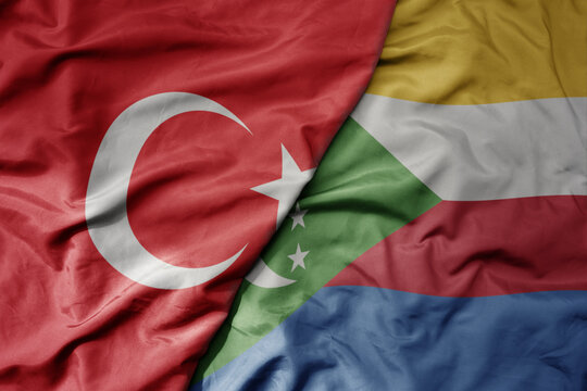 big waving national colorful flag of turkey and national flag of comoros .