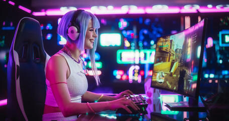 Fototapeta na wymiar Young Woman Playing Online Action Shooter Video Game on a Computer in a Futuristic Digital Space. Cosplay Girl with Blue Hair Streaming Futuristic Entertainment Content for Internet Fans