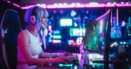 Obraz na płótnie Canvas Young Woman Playing Online RPG Strategy Video Game on a Computer in a Futuristic Digital Space. Cosplay Girl with Blue Hair Streaming Futuristic Entertainment Content for Internet Fans