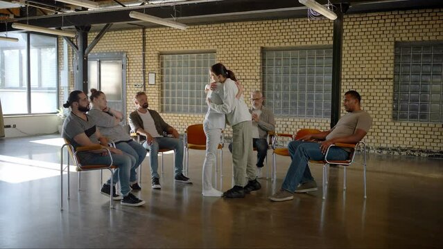 Therapist hugging young woman during rehabilitation session