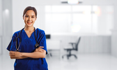 Portrait healthy asian female surgeon in blue dress with stethoscope standing crossed hands smiling friendly looking at camera standing smartly in abstract medical facility examination room. - Powered by Adobe