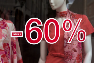 Closeup of 60 % sign on fashion store window on summer clothes background - 635495049