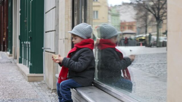 Child in the center of Prague, eating traditional czech dessert trdelnik in the city center