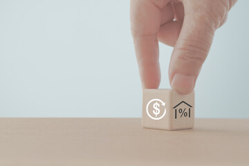 Home loan, refinance, mortgage and buy real estate concept. Hand turned wooden cube blocks for  percent inside house to dollar sign inside circle icon including copy space