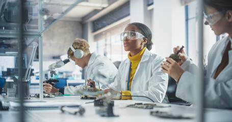 Modern Science Research Laboratory in University: Diverse Young Scientists in White Coats Using...