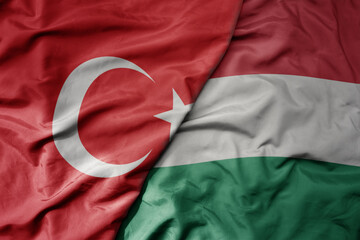 big waving national colorful flag of turkey and national flag of hungary .