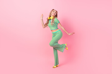 Full body photo of pretty young girl entertainment dance earphones dressed stylish green print outfit isolated on pink color background