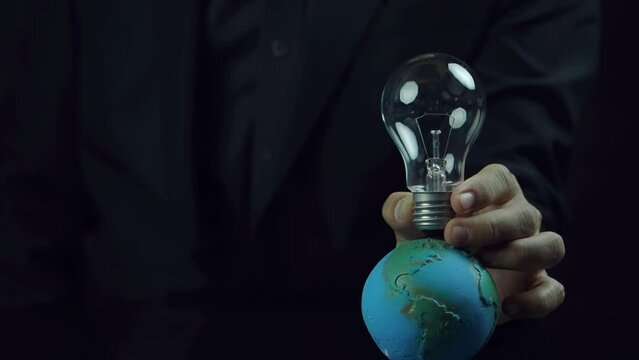 Businessman showing light bulb with ESG icons and virtual tree. Concept of ecological, renewable energy and save environment. Sustainable organizational development, society and corporate governance.
