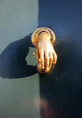 beautiful traditional door handle in the shape of a hand in gold colour