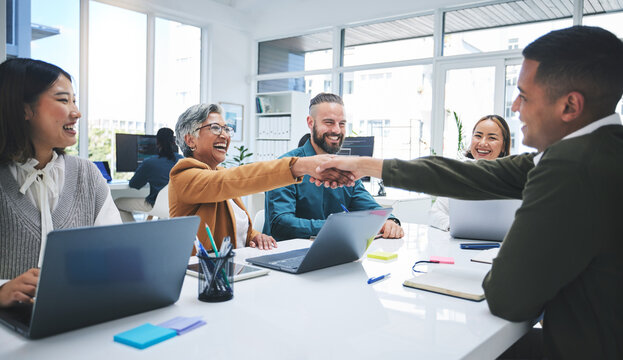 Creative people, handshake and meeting in hiring, partnership or deal agreement together at the office. Group of employees shaking hands in recruiting, company growth or startup at the workplace