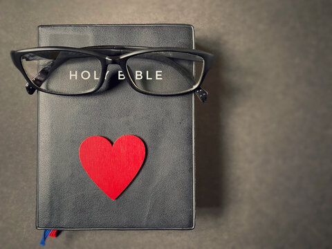 Red heart and glasses Holy Bible. Bible reading, discerning God words, to devote and love Christianity, knowledge, truth and spiritual understanding concept.