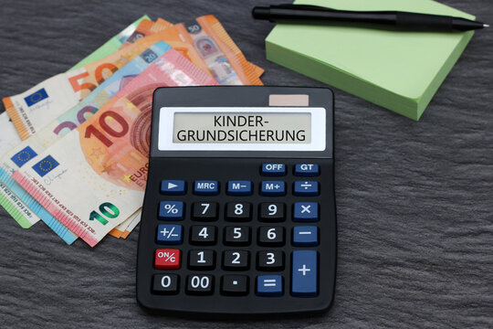 Display eines Taschenrechners mit dem Wort Kindergrundsichedrung und Euro Banknoten.	