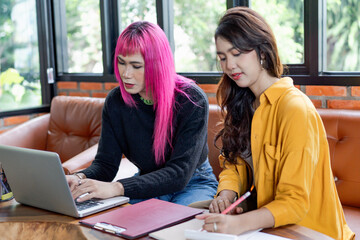 LGBTQ+ transgender man Beautiful Authentic Specialist with Pink Hair and Non-binary trans working together Working Design in creative workplace team work colleagues Gender equality