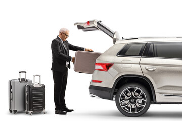 Businessman putting suitcases in the trunk of a SUV
