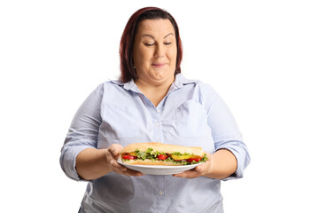 Overweight woman holding a sandwich on a plate