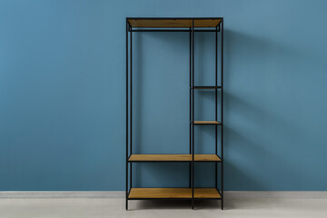 Empty shelving unit near blue wall in room