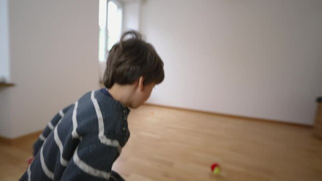 Child's Indoor Tennis Exercise practice in Unfurnished Apartment Room, hitting ball with racket against wall, Relocating Family concept