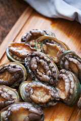 Fresh abalone on a wooden cutting board