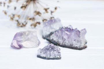 The stones of Amethyst mineral on a white wooden background, close up.
