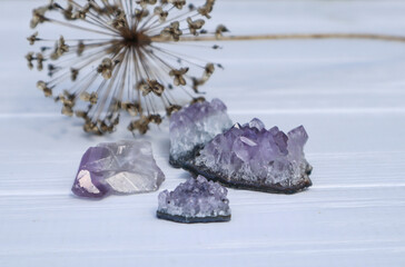 The stones of Amethyst mineral on a white wooden background, close up.
