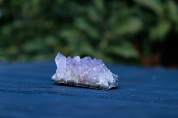 Amethyst semi precious gemstone on a blue wooden background.