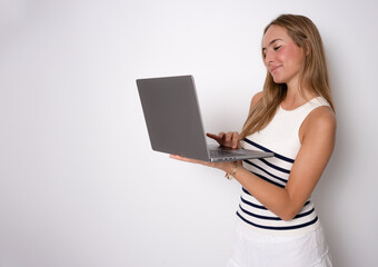 Image of cheerful young woman standing isolated over white background using laptop computer.