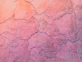 A close-up of a cracked pink salt lake at sunset creating abstract patterns. Salt production plants evaporated a brine pond in a salt lake. Salin de Giraud saltworks in Camargue, Provence, France