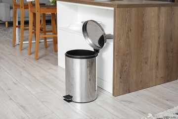 Opened metallic trash bin in interior of modern kitchen