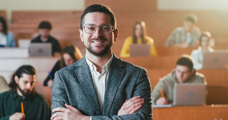 Portrait of Caucasian happy male teacher in glasses turning to camera and smiling joyfully at...