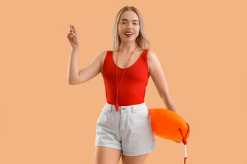 Female lifeguard with rescue buoy saluting on beige background