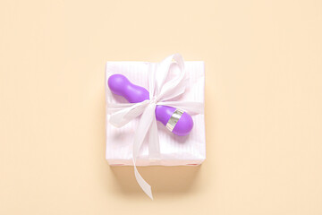Gift box and vibrator on beige background