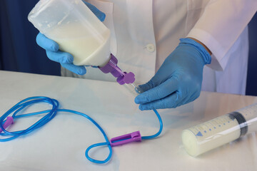 Enteral nutrition diet beeing prepared by a healthcare professional wearing gloves. Professional...