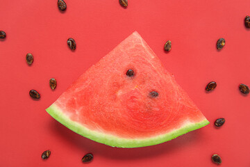 Composition with piece of ripe watermelon and seeds on red background, closeup