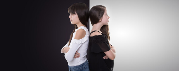 good and bad sisters wear black and white shirts and stand back to back with crossed arms look...