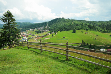 View of wooden fence and mountain village in Carpathians, Ukraine