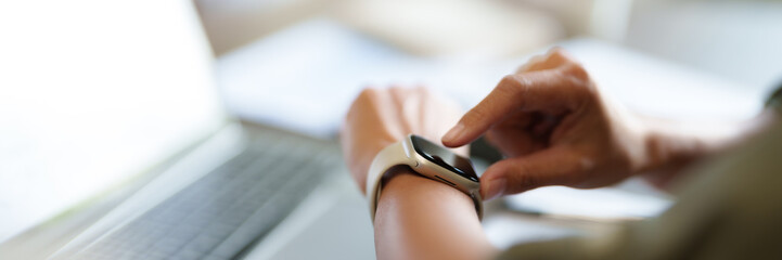 Close up business people using smartwatch at work.