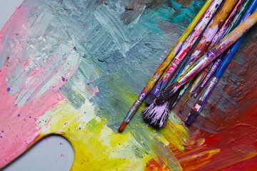 Dirty paint brushes on colorful background