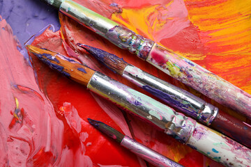 Obraz premium Dirty paint brushes on colorful background